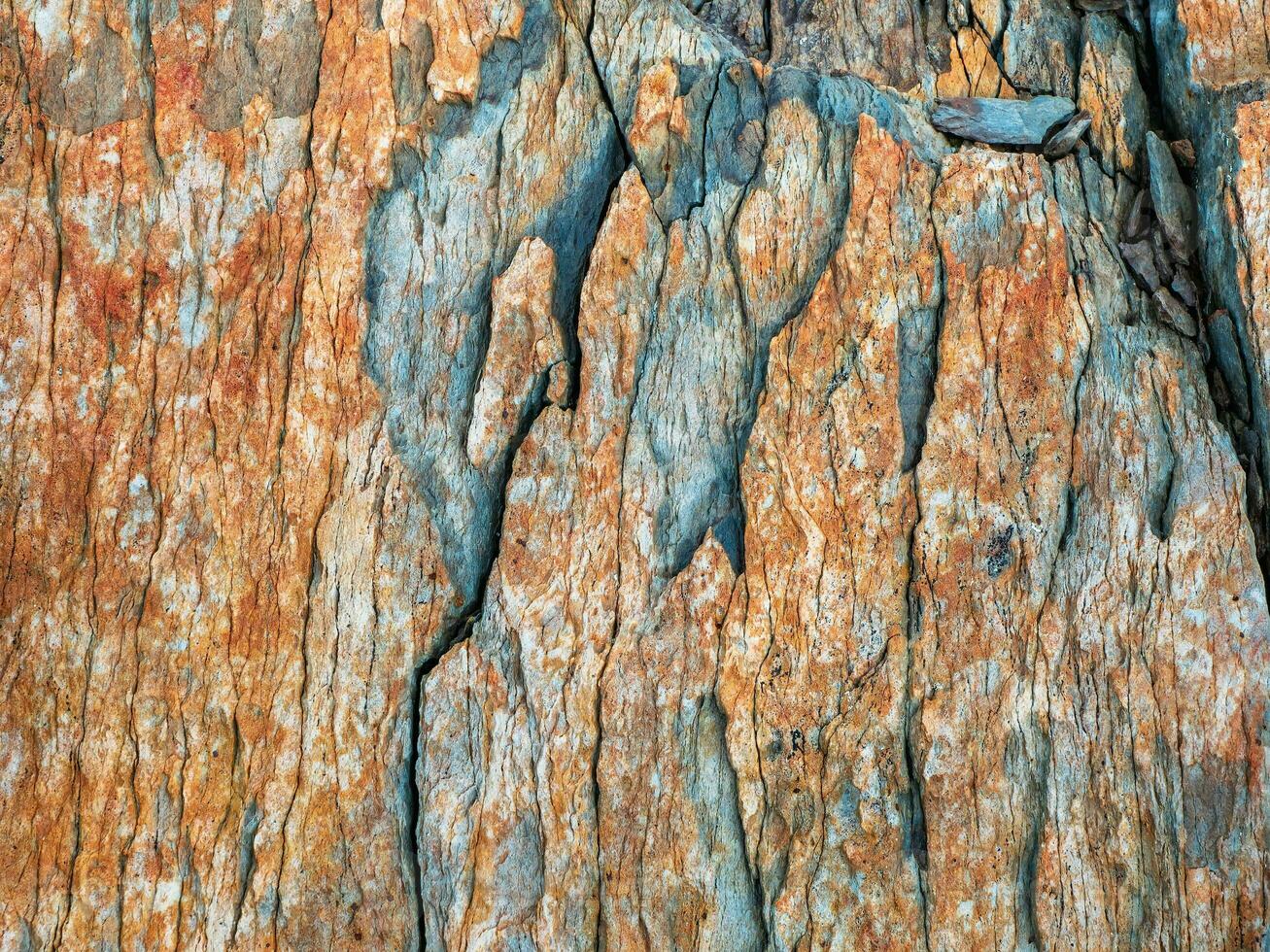 Layered mountain texture. Stone texture. Cross section of rocks. Geological layers. Colored layers of stones in section of the mount, different rock formations and soil layers. photo