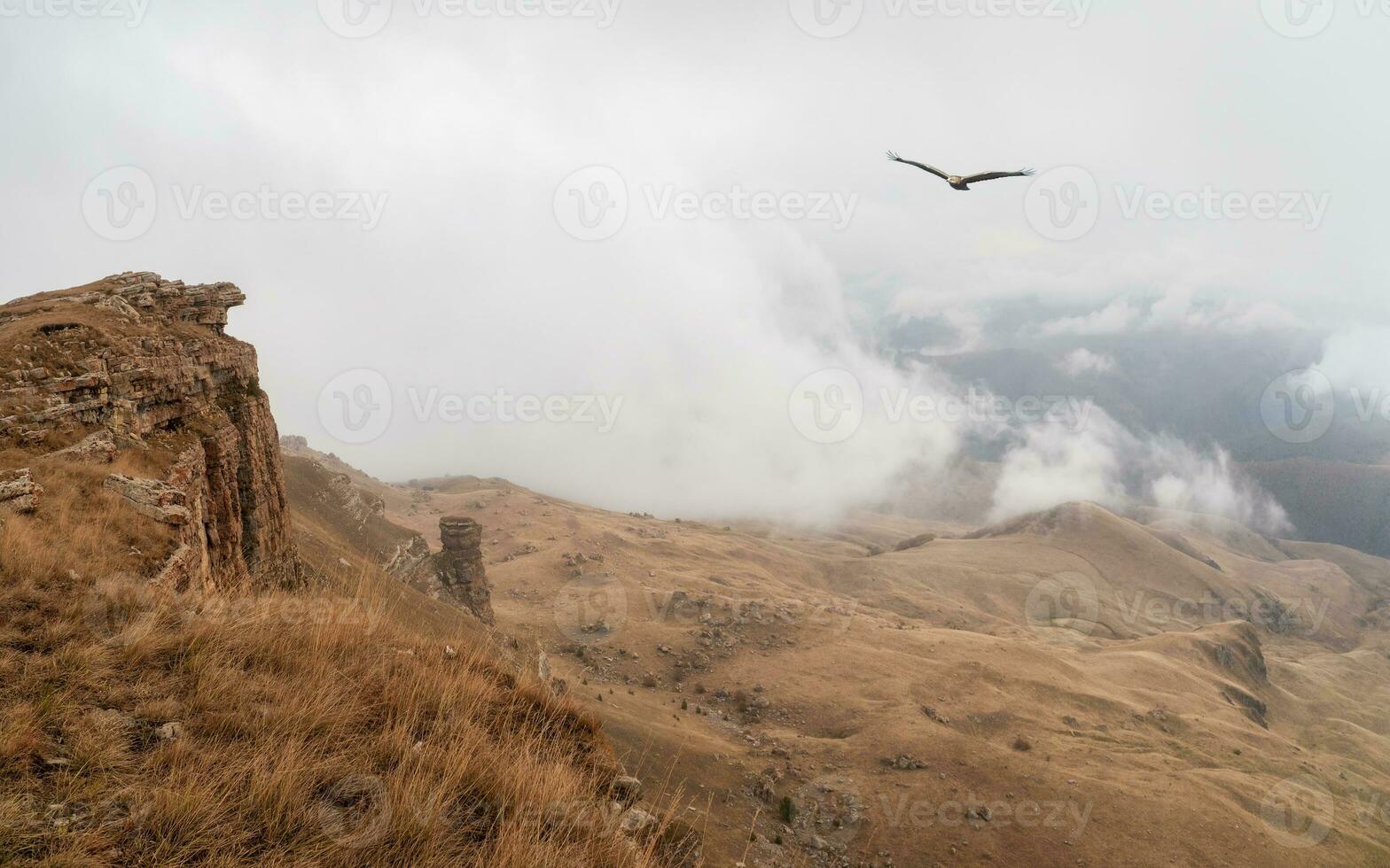 Low dense clouds over a mountain valley. Beautiful panoramic view to red mountain peaks over thick clouds. photo
