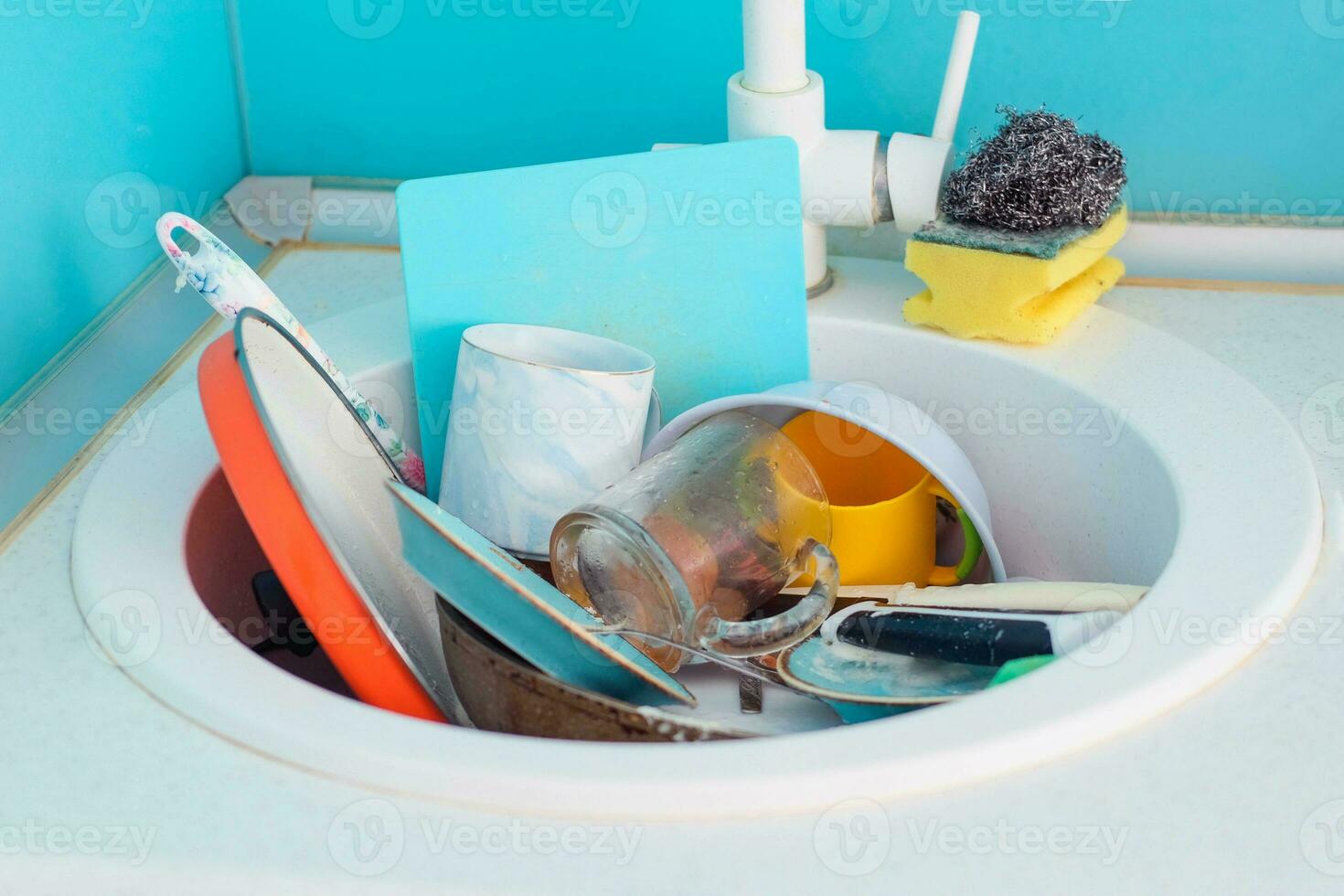 Sink with a pile of dirty dishes. Complete washing of crockery, tableware. Unsanitary conditions. photo