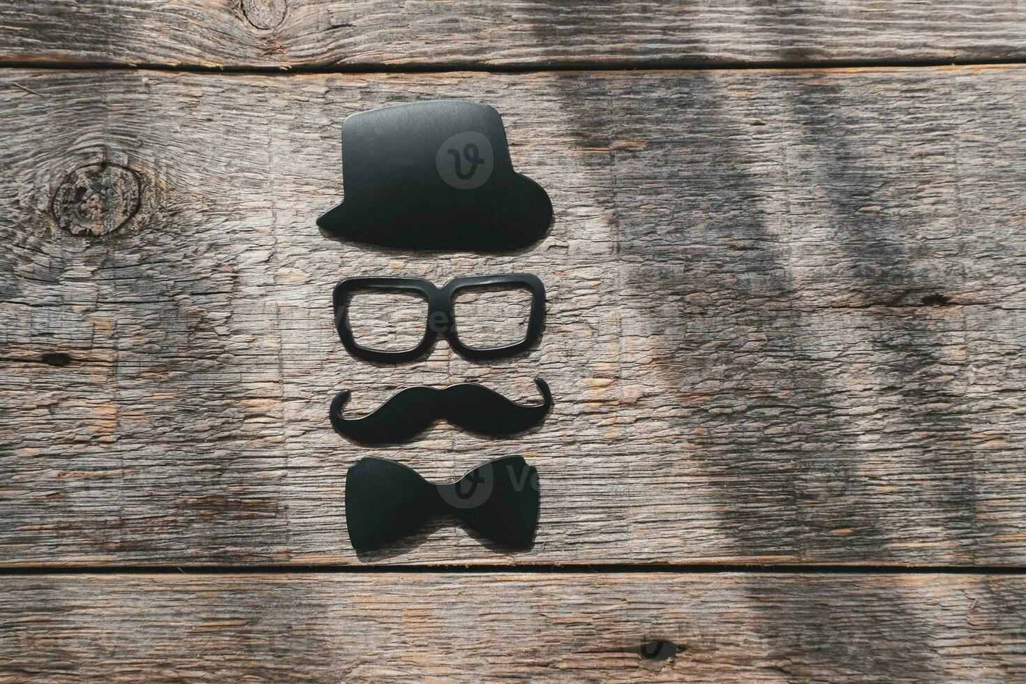 Happy fathers day sticker, hat, glasses, black mustache on a wooden background. Hipster objects. Father's day is a holiday photo