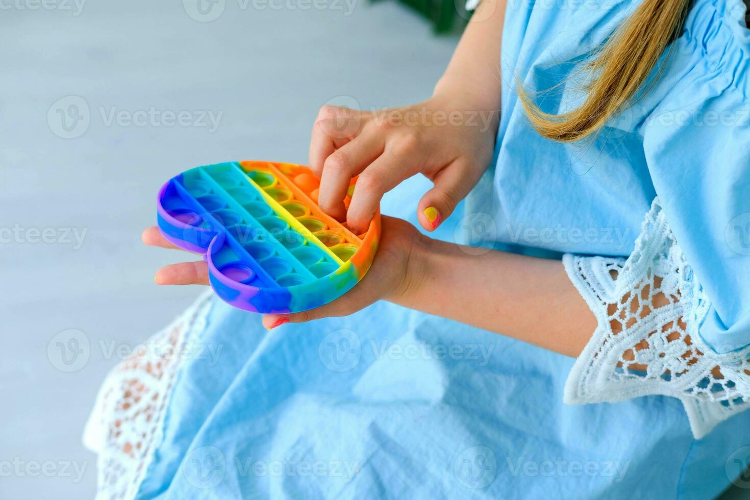 niño jugando con arco iris popular eso agitarse juguete. empujar burbuja agitarse sensorial juguete - lavable y reutilizable silicio estrés alivio juguete. anti estrés juguete para niño con especial necesidades. foto