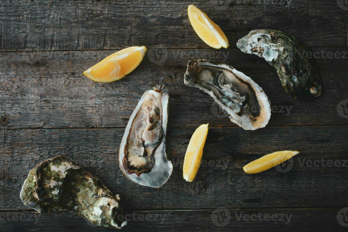 de cerca de Fresco abierto crudo ostras con limón y hielo en un de madera antecedentes. sano fruto de mar. ver desde arriba. Copiar espacio. fruto de mar. gastrónomo alimento. foto