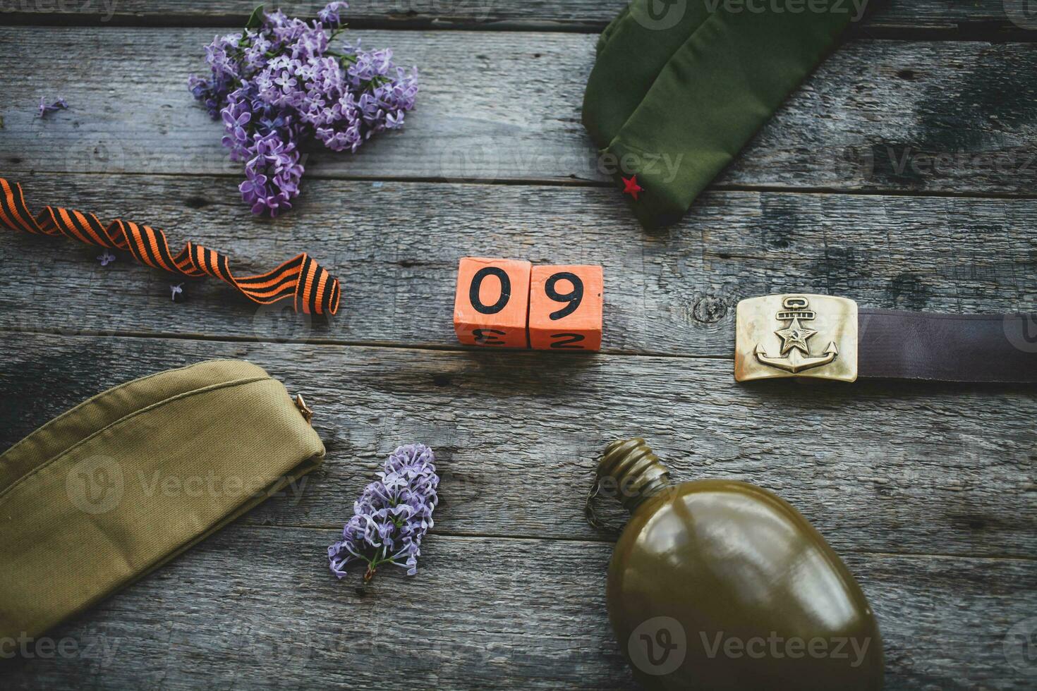 Flask, cap , george ribbon and lilac, soldier belt with a five-pointed star with a hammer and sickle and a wooden calendar with the date  May 9.  Victory Day. photo