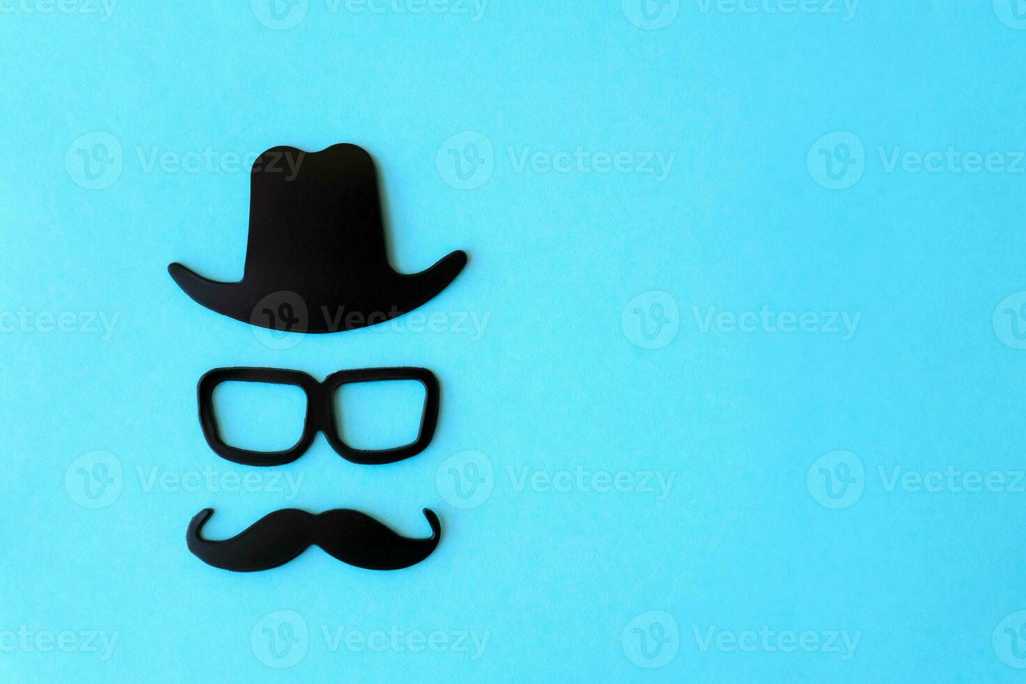 Happy fathers day sticker, black hat, glasses and mustache on a blue background. Hipster objects. Father's day is a holiday. Design Blank space for lettering. photo