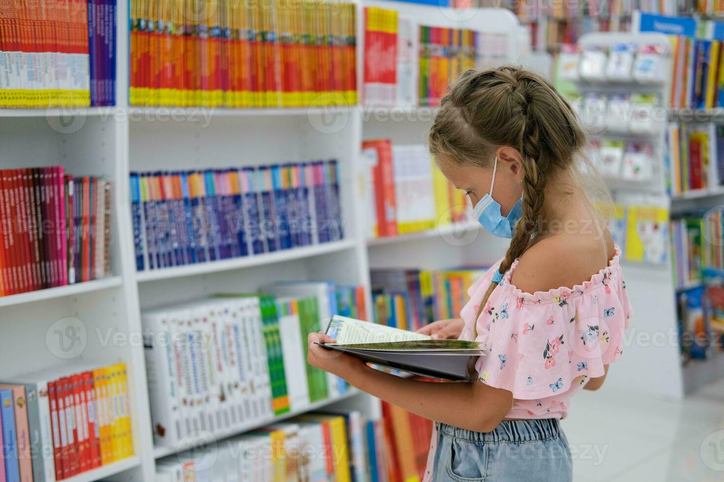 un niña en un médico máscara en un compras centrar compra papelería para escuela. preparando para colegio después cuarentena codicioso - 19 foto