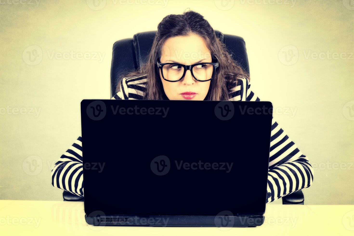 Suspicious businesswoman on the laptop photo