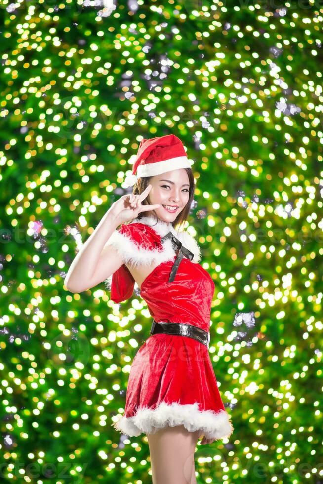 Pretty Asian girl in Santa costume for Christmas with night light photo