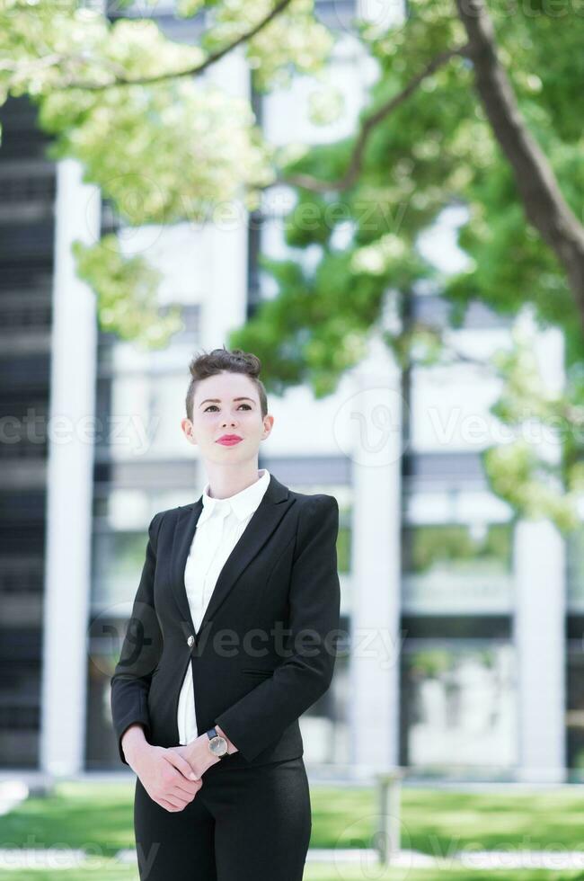 Modern business woman standing and loooking out photo
