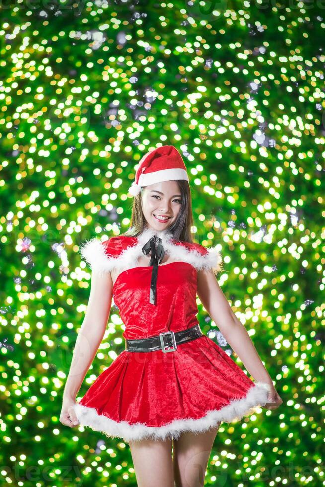 Pretty Asian girl in Santa costume for Christmas with night light photo