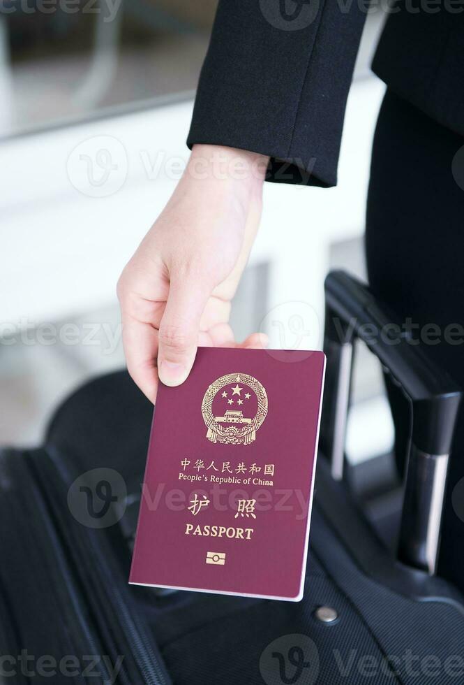 Hand holding China passport, ready to travel photo