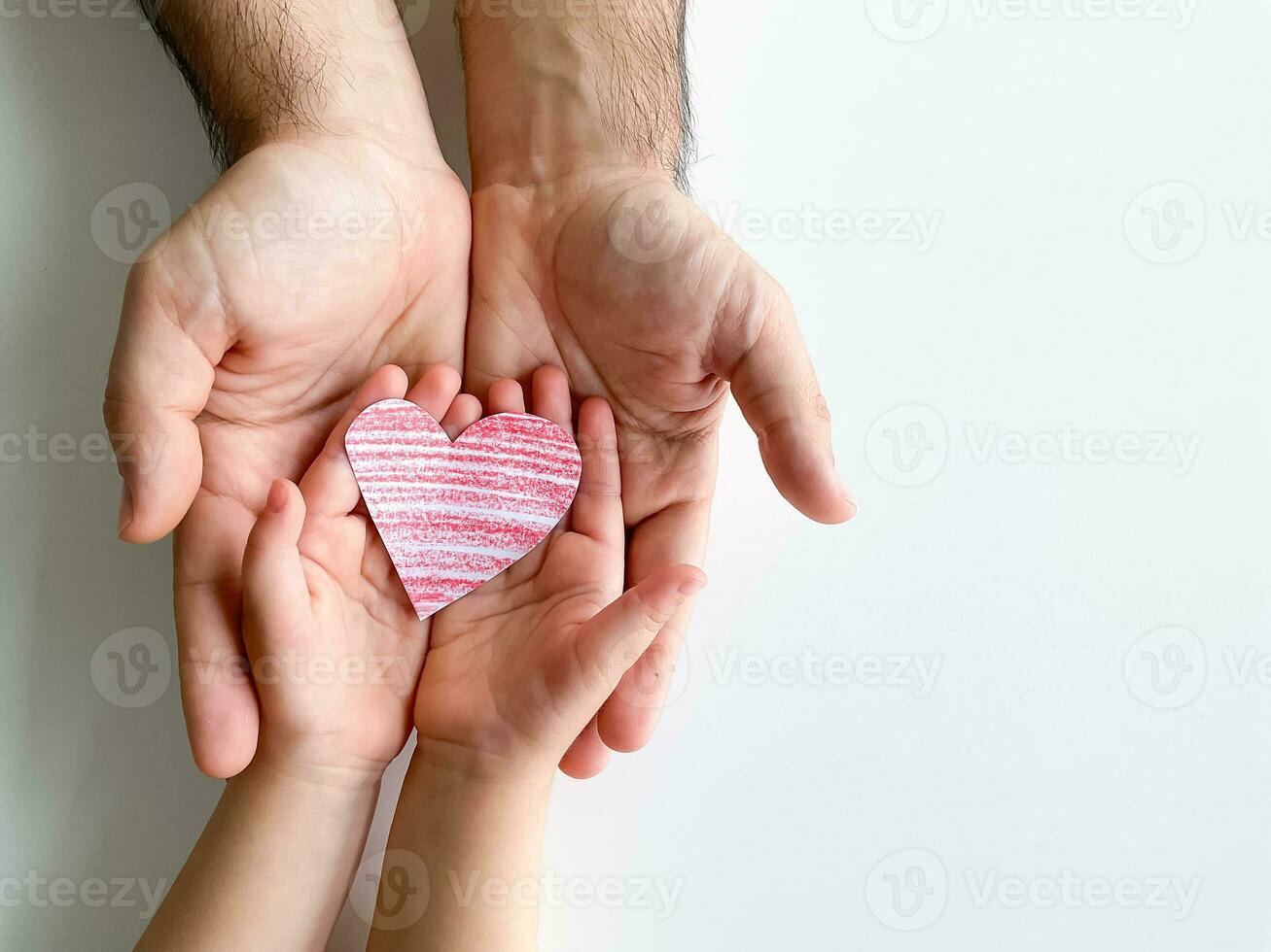 adult and childrens hands hold small red paper heart. Fathers Day. Family, love photo