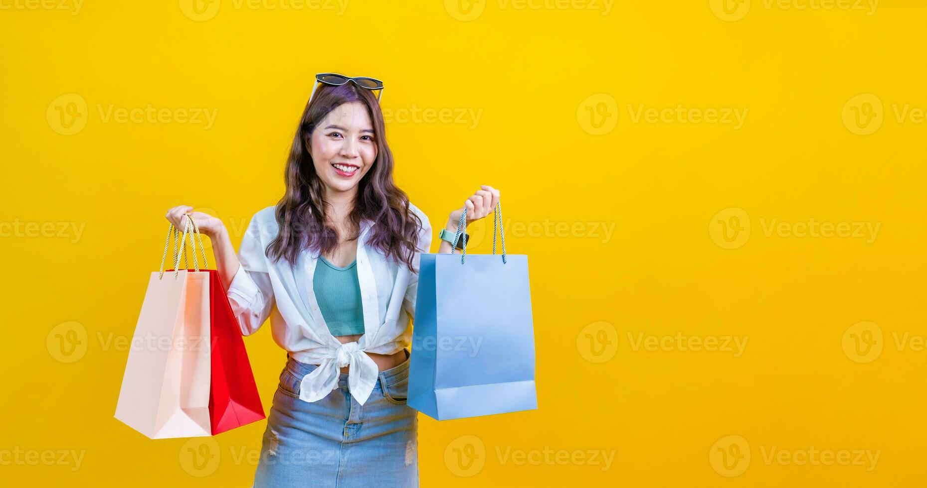 Beautiful Attractive Asian Woman smile and holding luxury shopping bags  feeling so happiness and enjoy with black Friday sale in Shopping  mall,isolated on white background. Shopping Lifestyle Concept Stock Photo