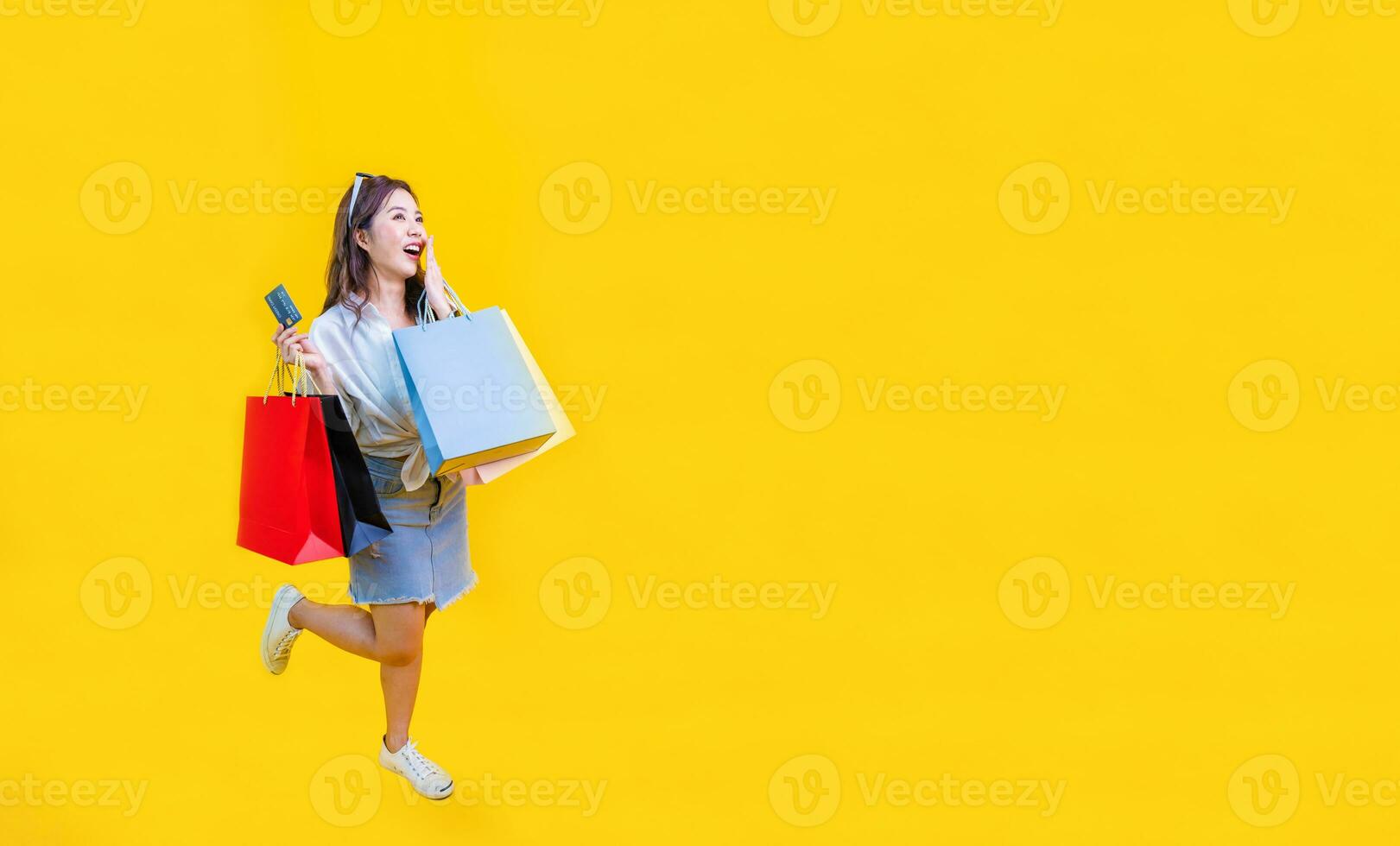 bonito asiático mujer en de moda verano Moda es sonriente y participación compras bolso en felicidad para descuento rebaja aislado en amarillo antecedentes para publicidad y promoción evento concepto foto