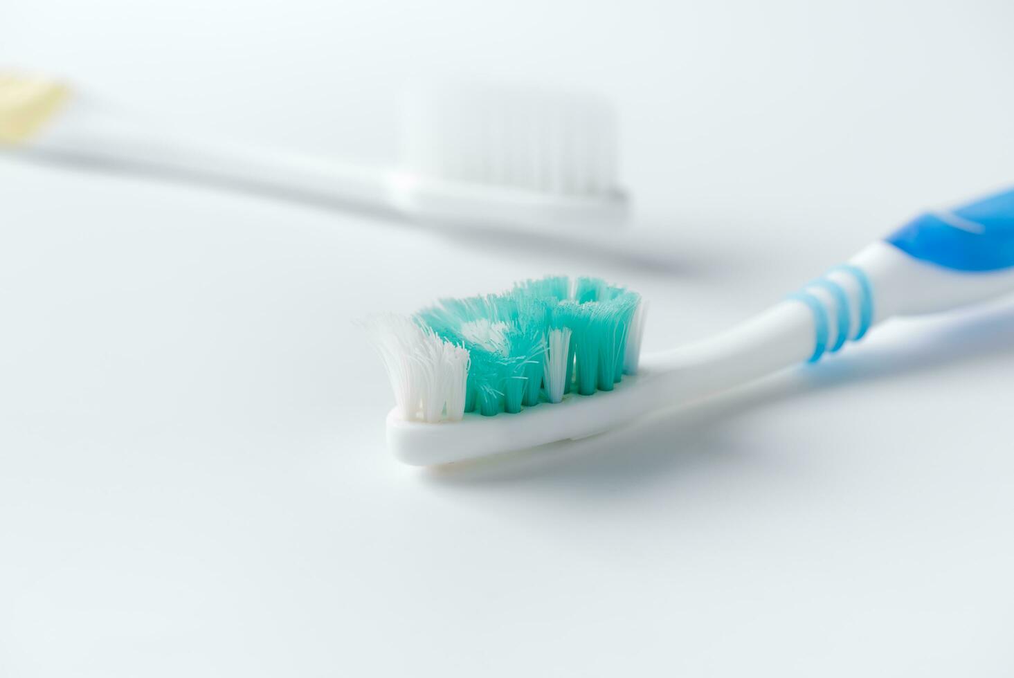 Used toothbrush and new toothbrush on white background photo