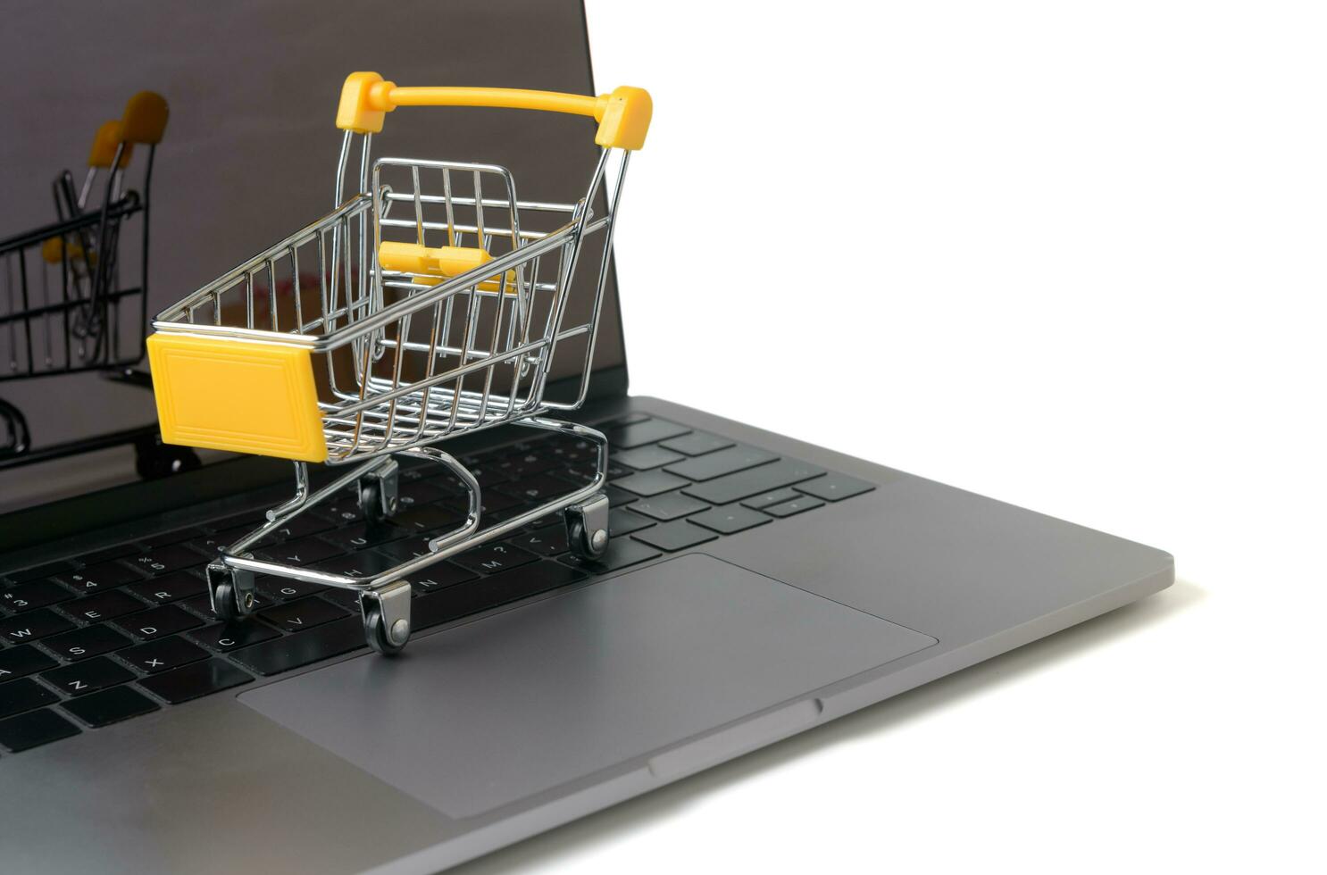 Trolley on a laptop keyboard isolated on white photo