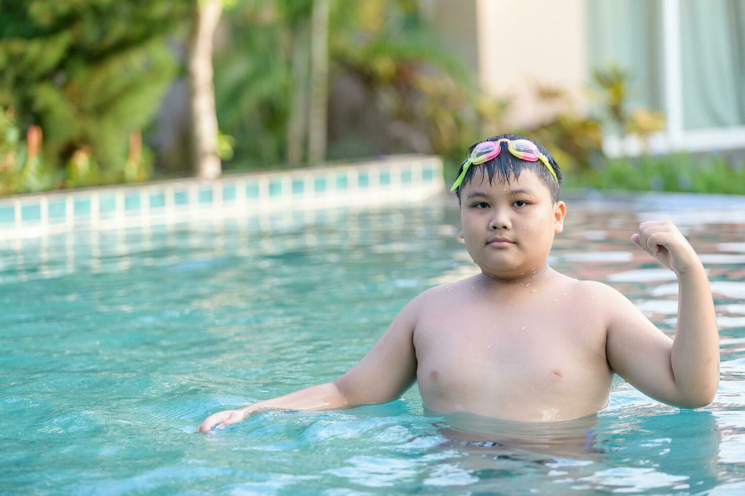 Obese fat boy show muscle in swimming pool photo