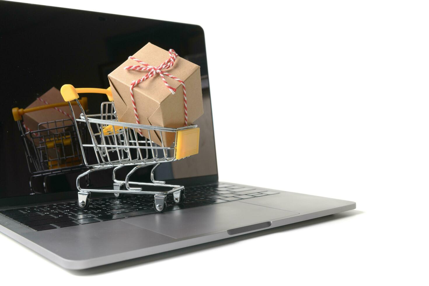 Boxes in a trolley on a laptop keyboard isolated photo