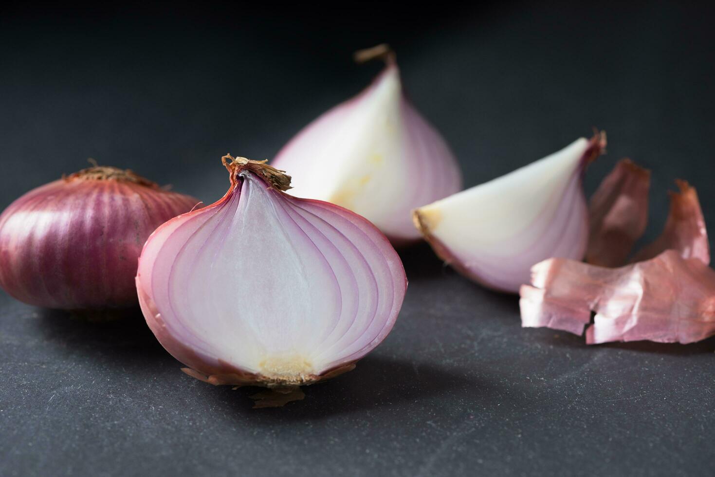 sliced red onions on black stone background photo