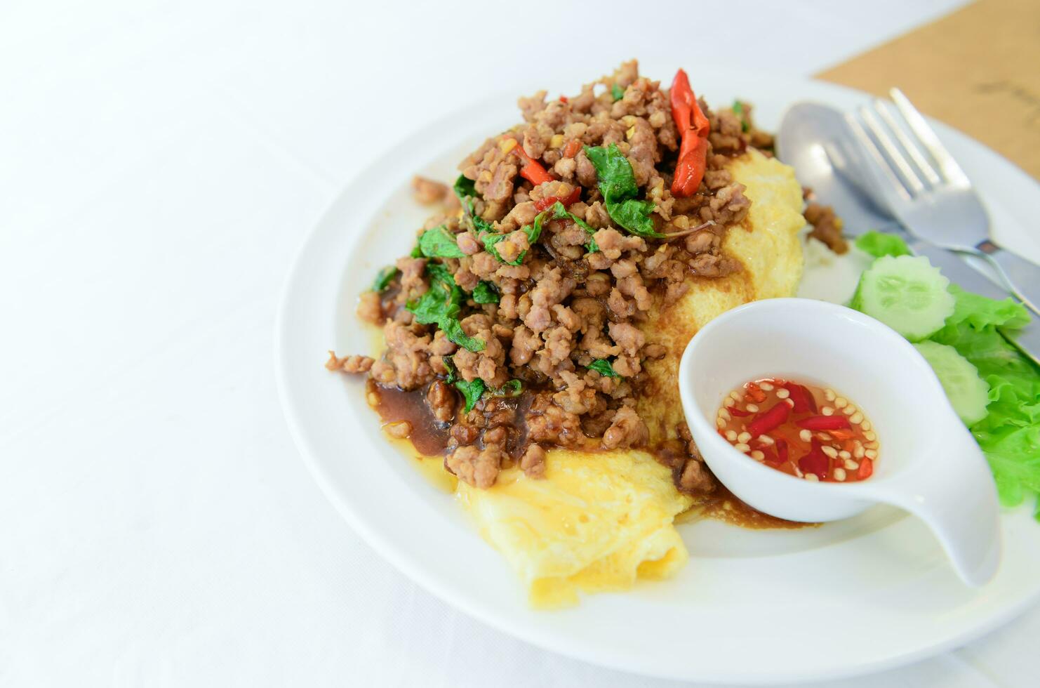 Fried basil with pork on an omelette and Fish sauce with chilli, photo