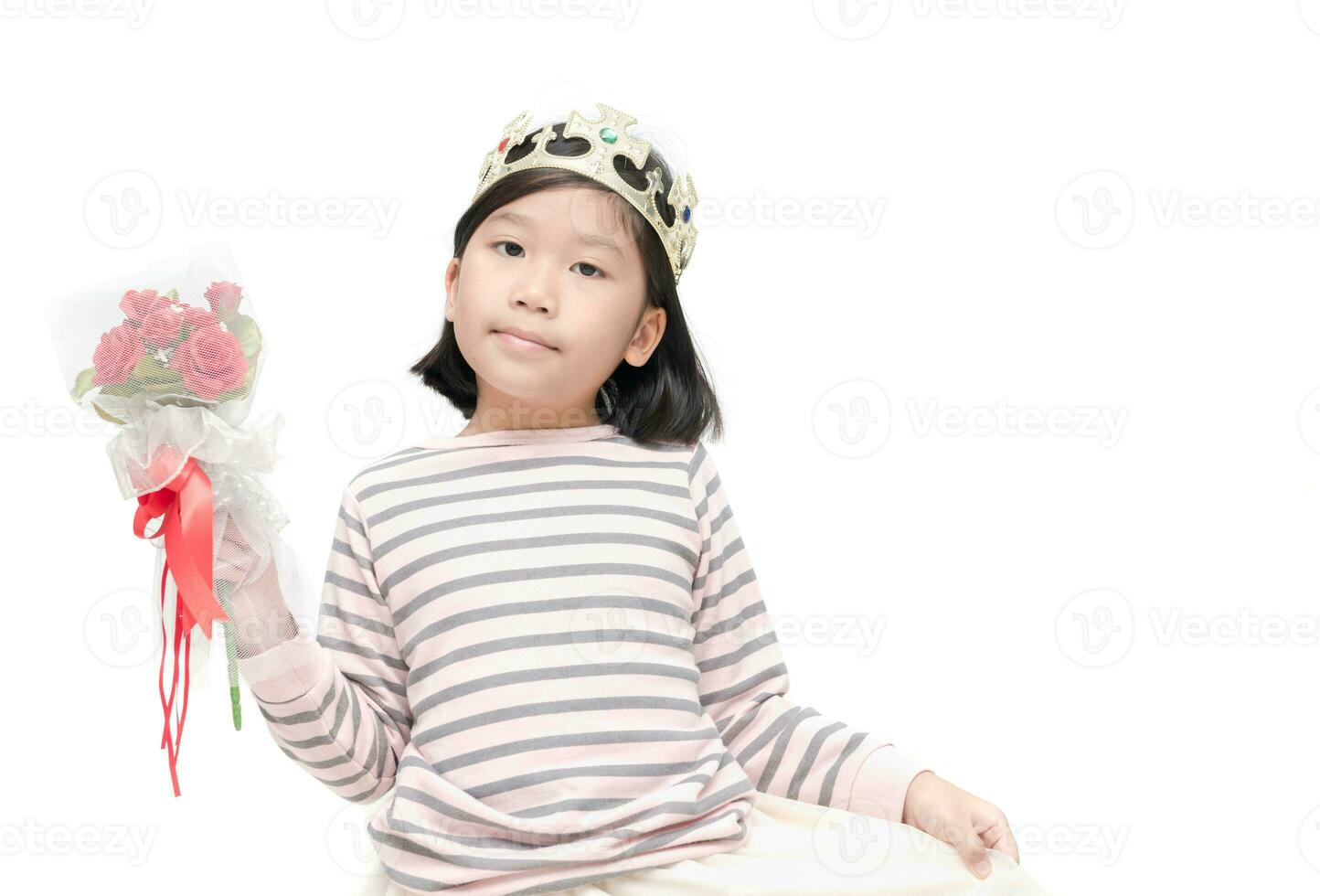 linda asiático niña vistiendo un corona y participación Rosa ramo de flores foto