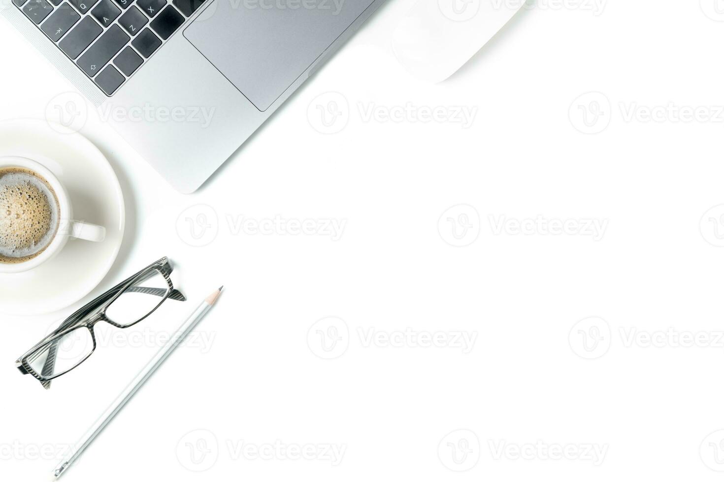 Desk with laptop, eye glasses, pencil and a cup of coffee photo