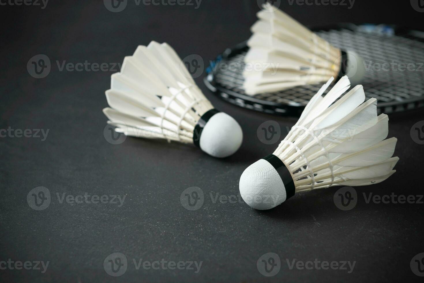 volantes y bádminton raqueta en negro antecedentes. foto