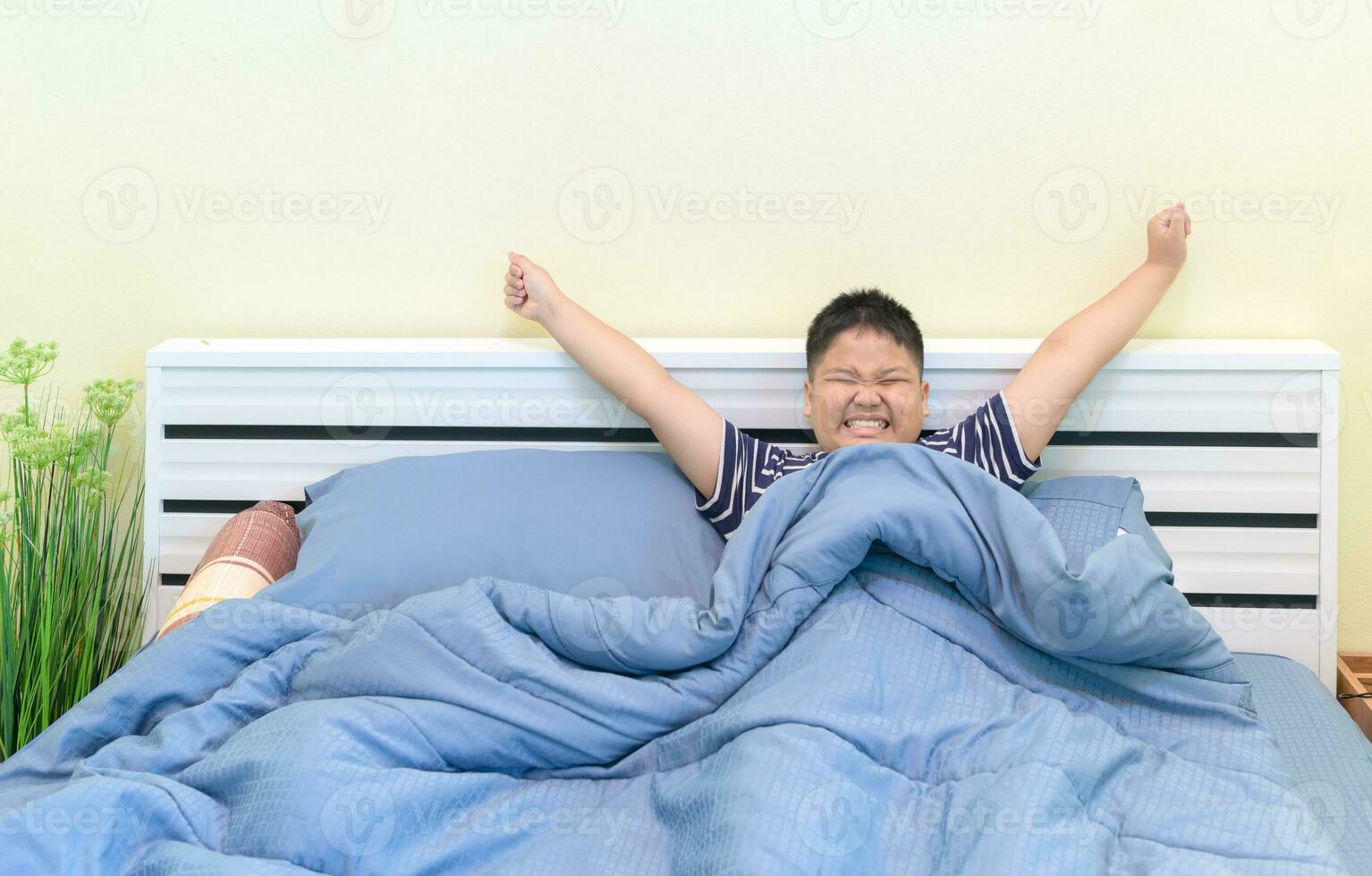 grasa chico extensión en cama después despertar arriba, foto