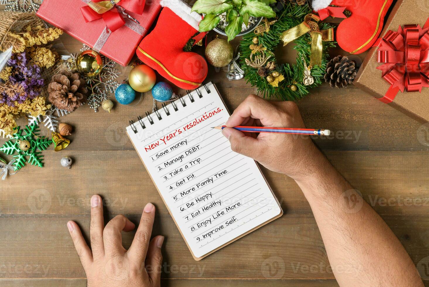 Hand man writing New year resolution on note paper photo