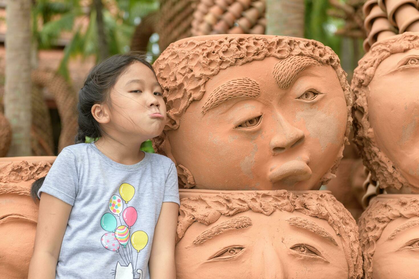 Girl showing bored or upset emotion near clay pots, photo