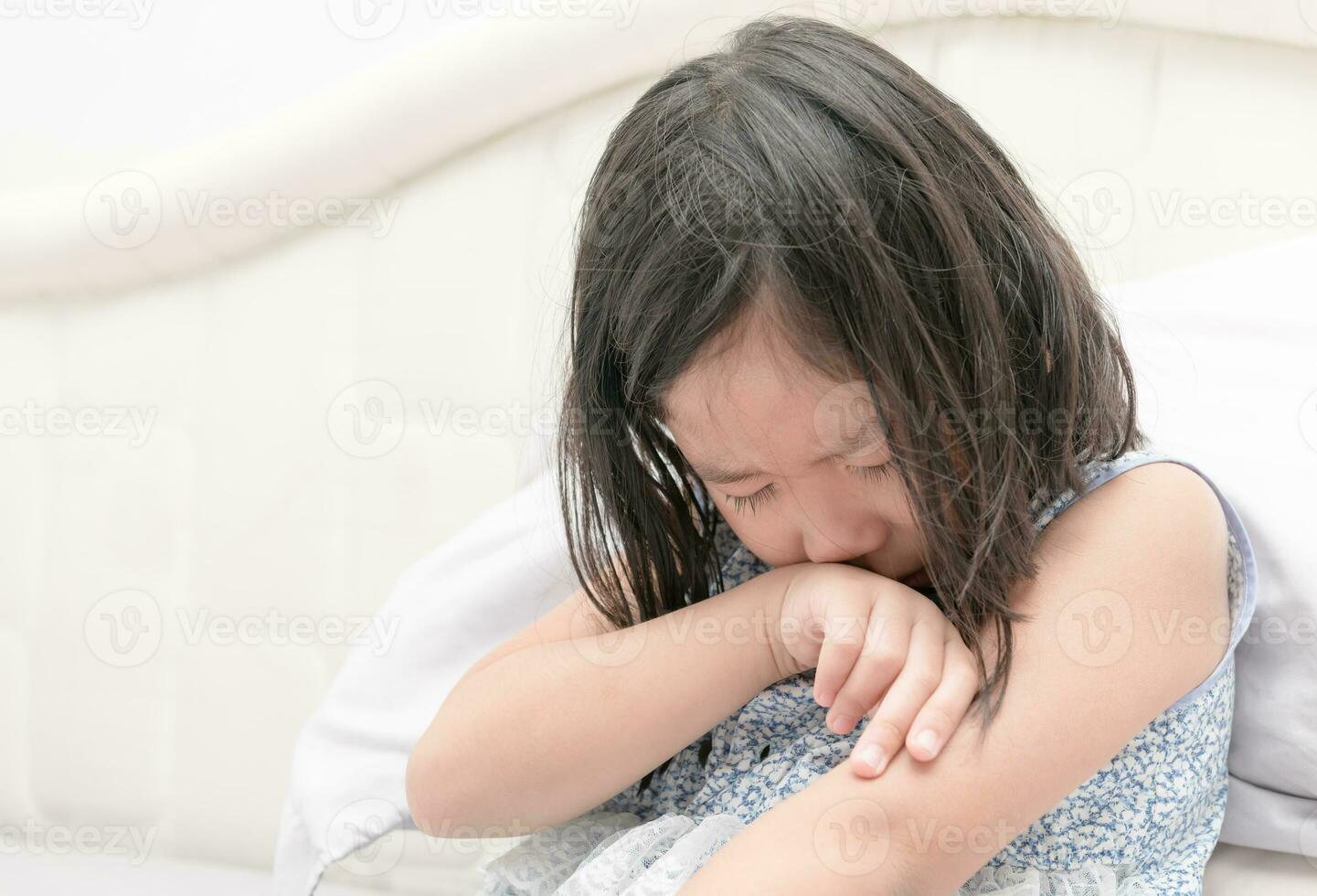 pequeño niña llorando en cama, triste y enojado foto