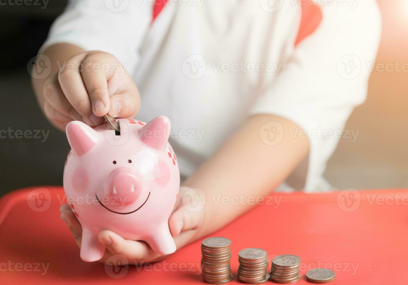 hand boy put coin to piggy bank, saving money photo