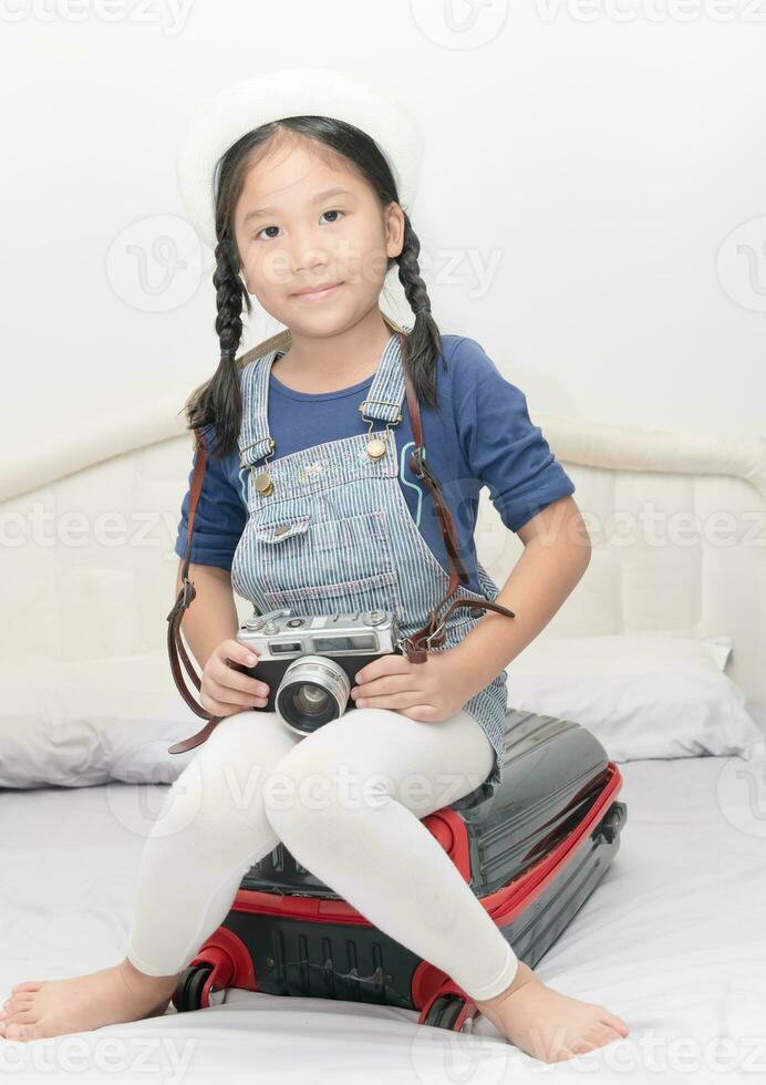 cute girl  hold vintage camera and sit on suitcase photo