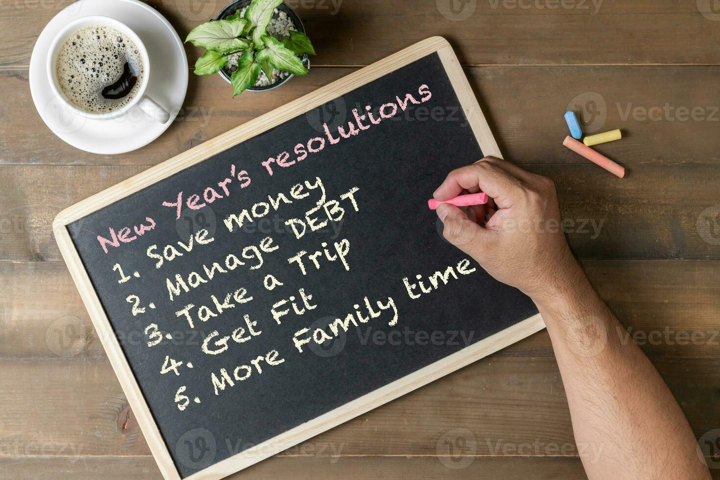 Hand man writing New year resolution on black board photo