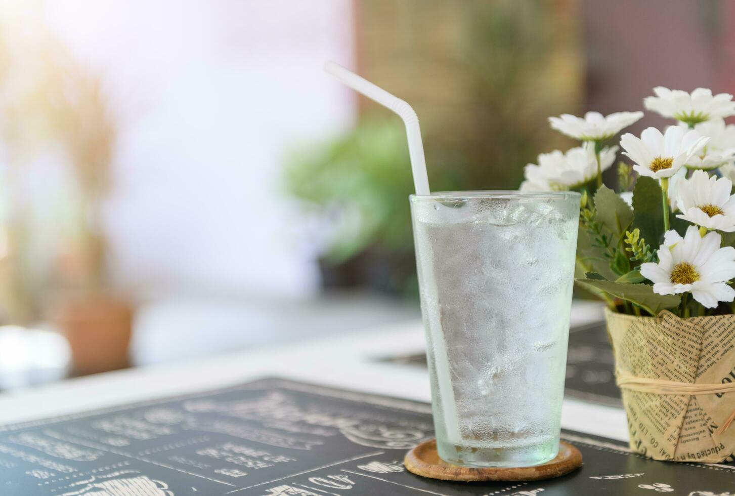 Glass of fresh water with ice on table photo