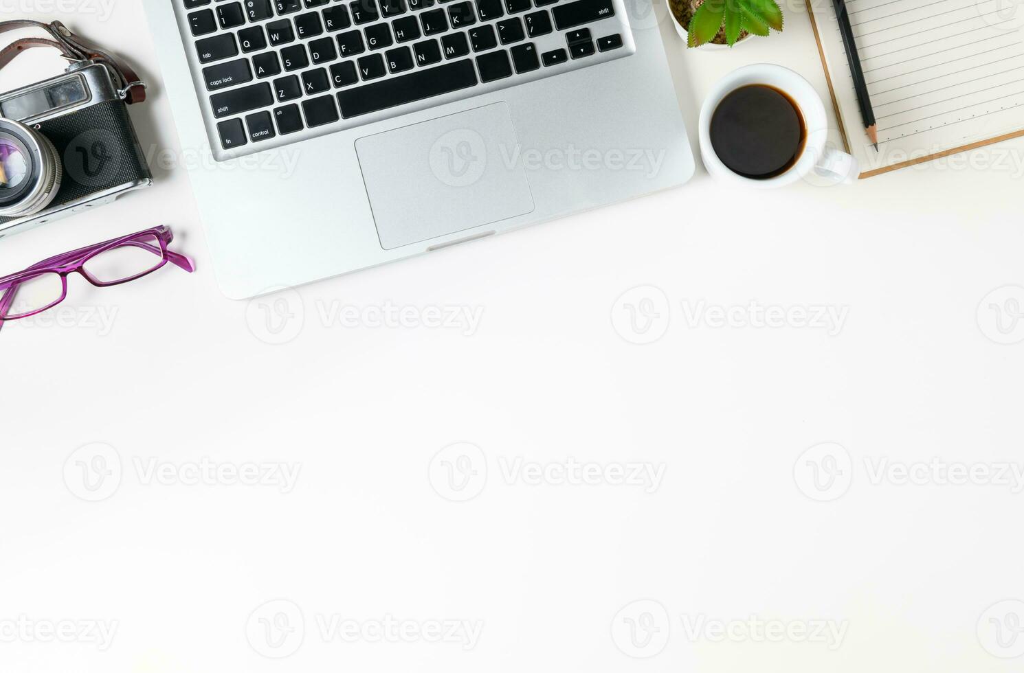 White office desk table with laptop computer and vintage camera photo