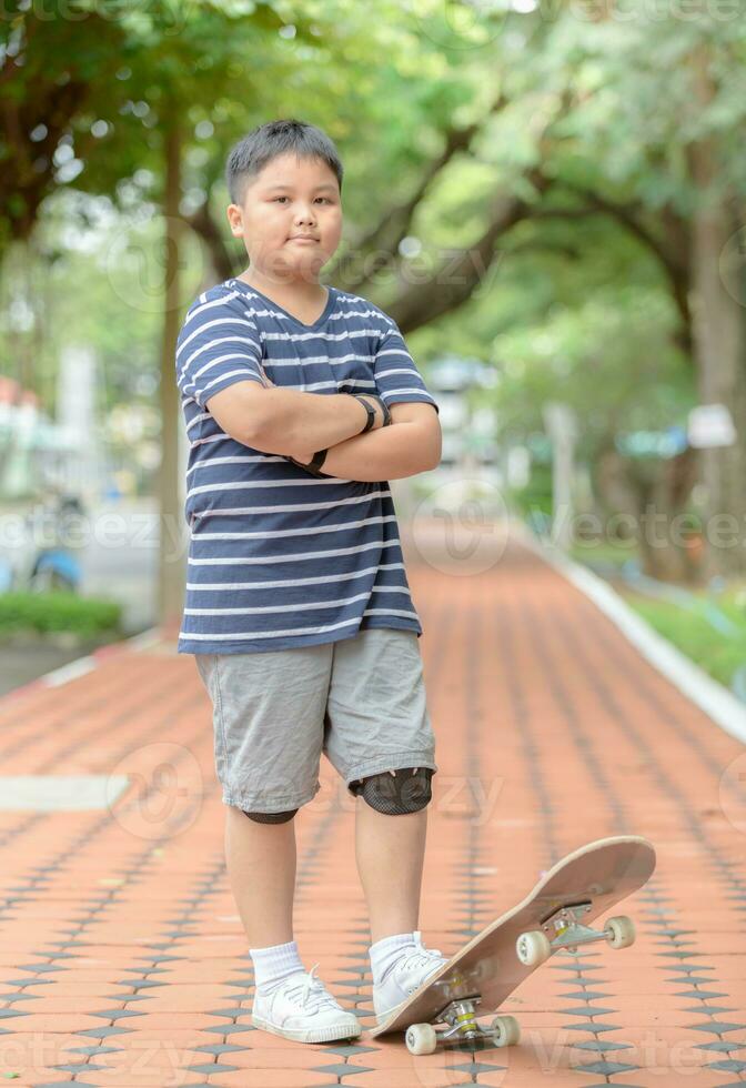 Obese boy stand on skate board photo