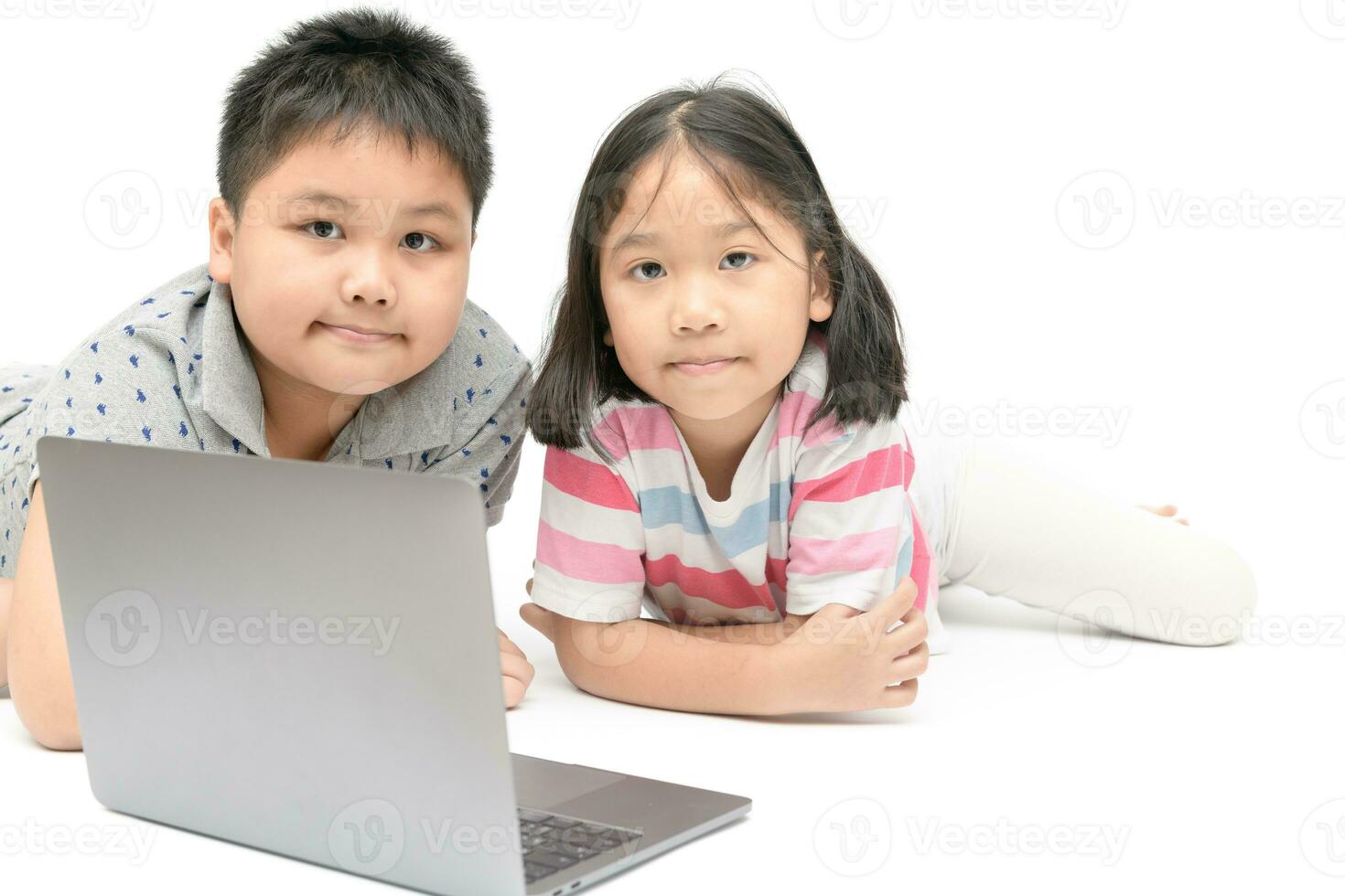 cute sister and young brother play laptop isolated photo