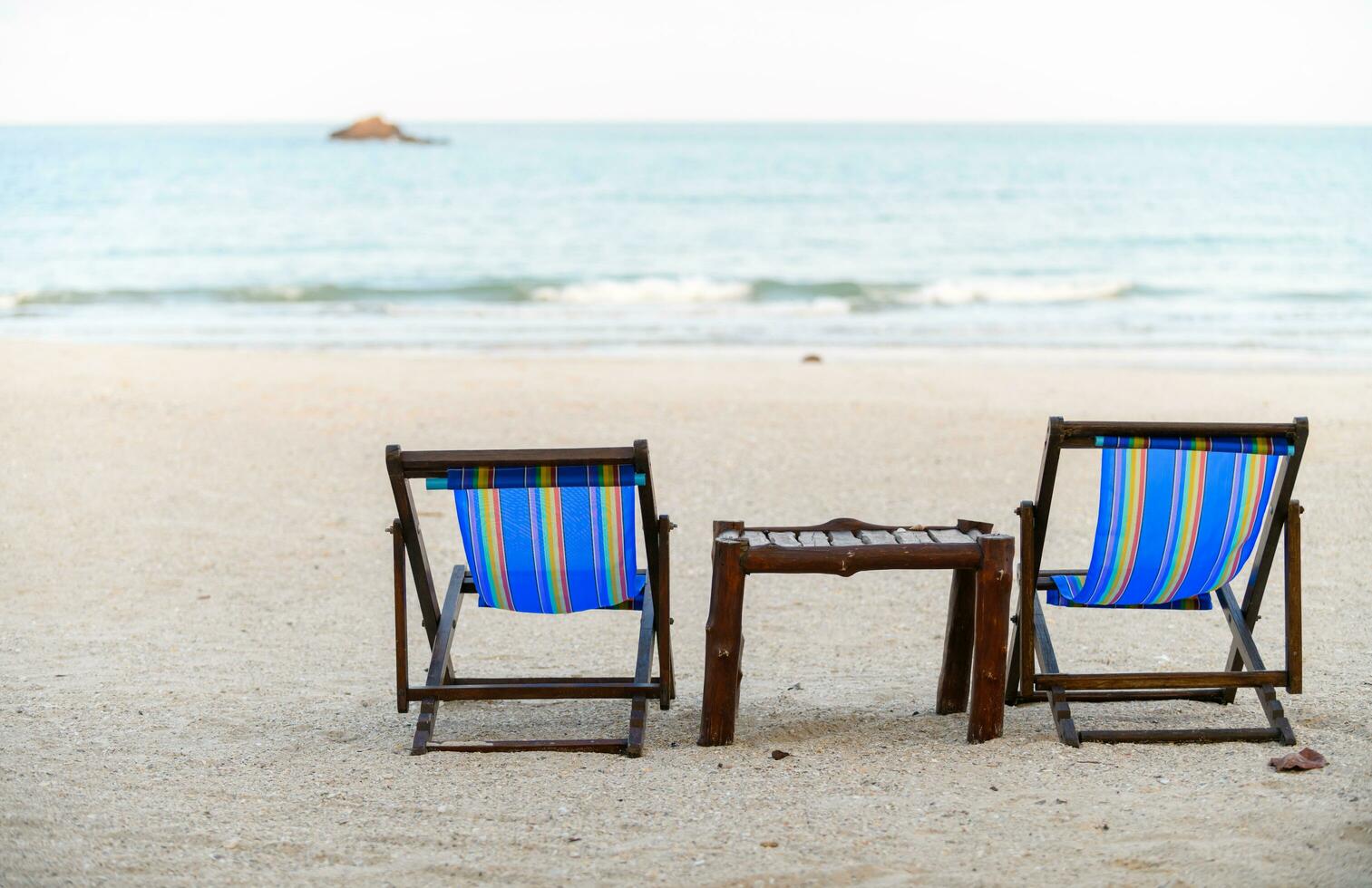 Two deck chair on the beach near sea, photo