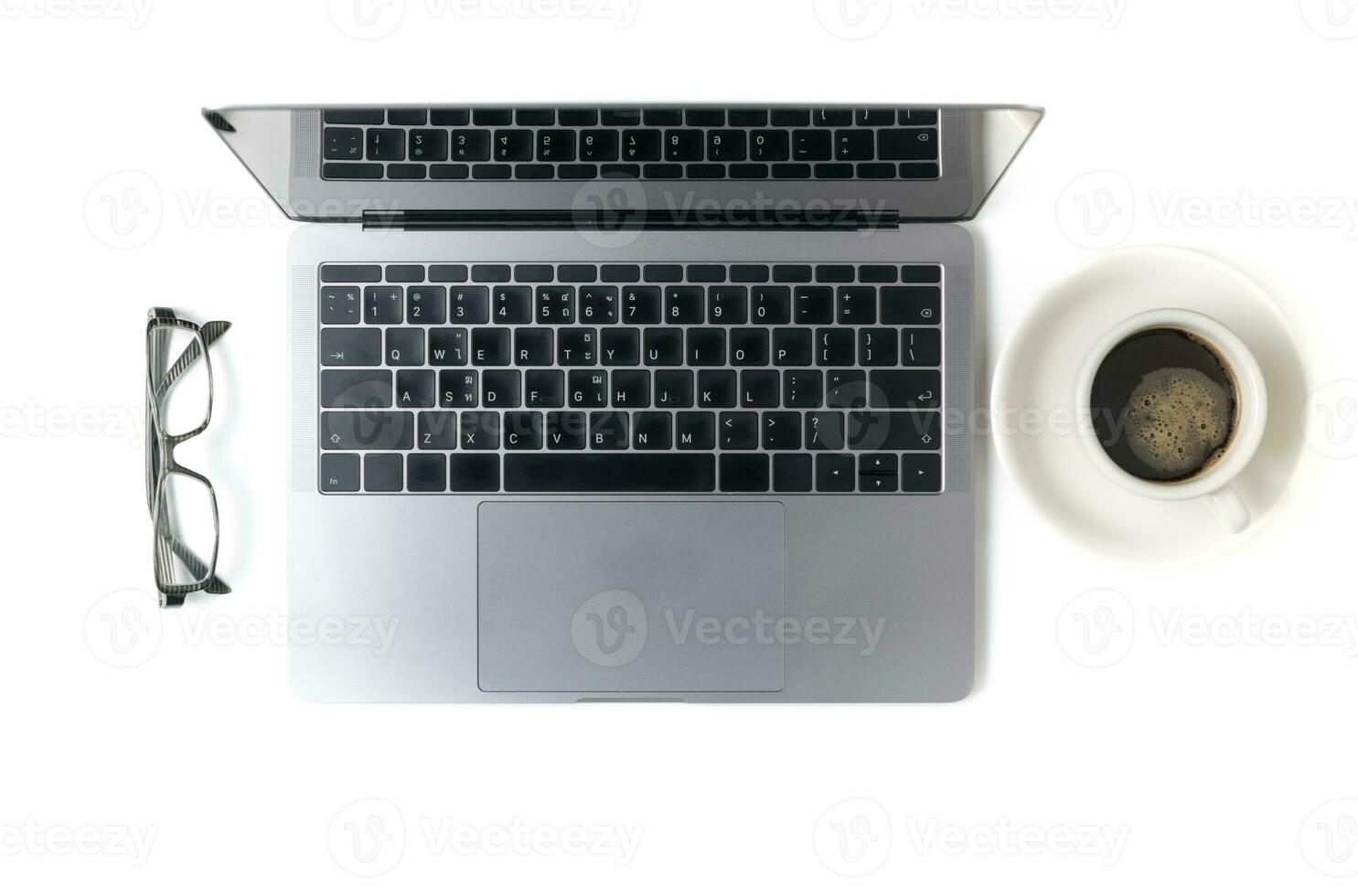 Modern workspace with coffee cup, glasses and laptop photo