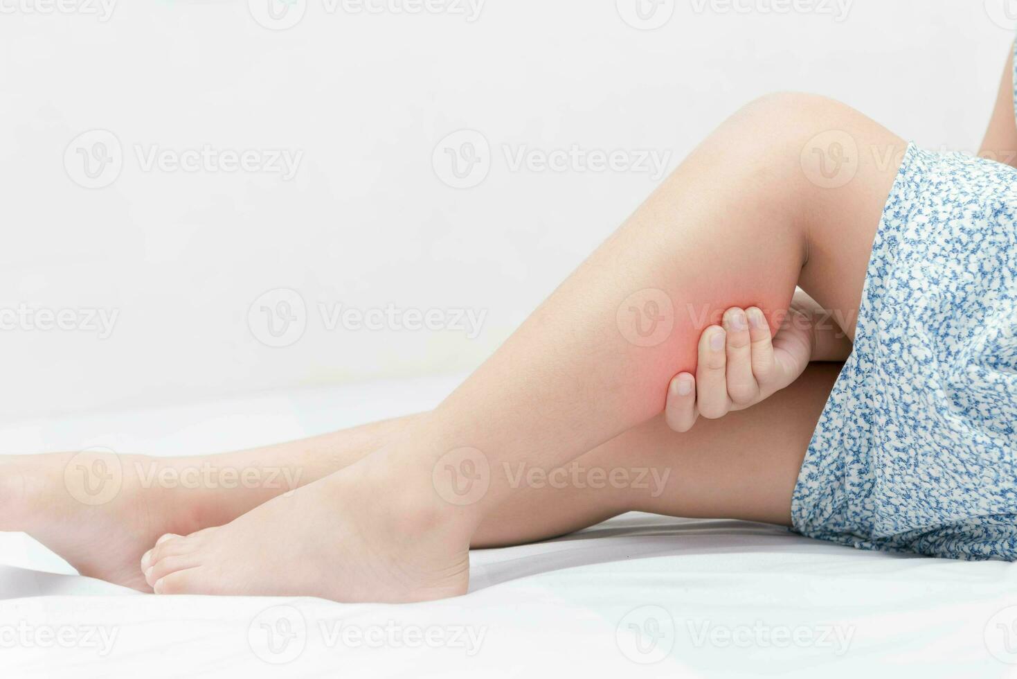 Leg pain in a girl on bed, photo