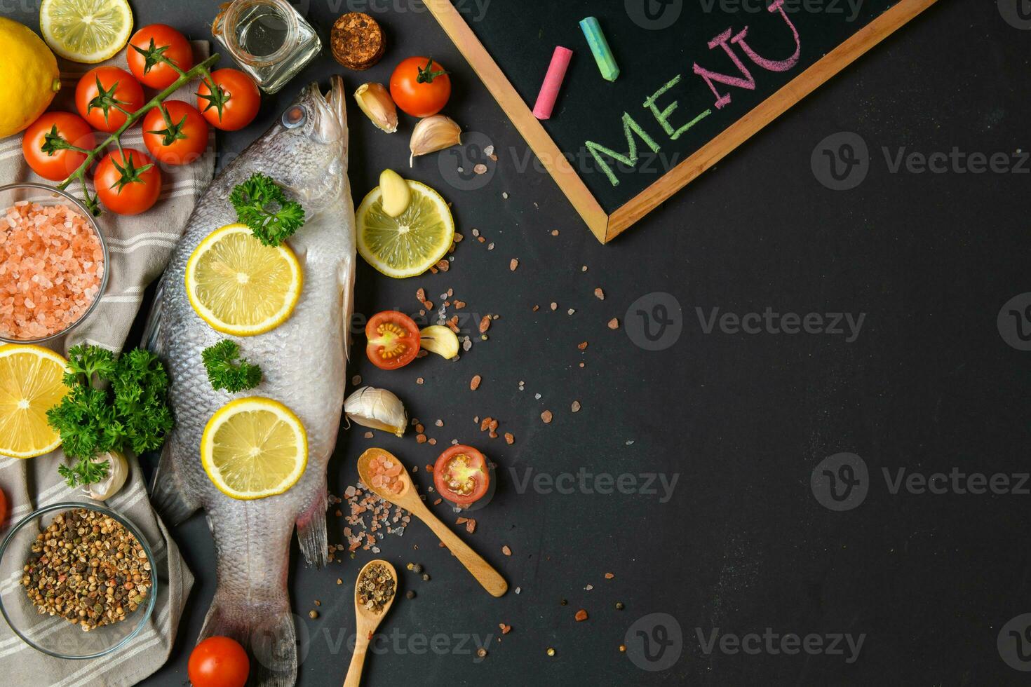Fresh fish seabass and ingredients for cooking. photo