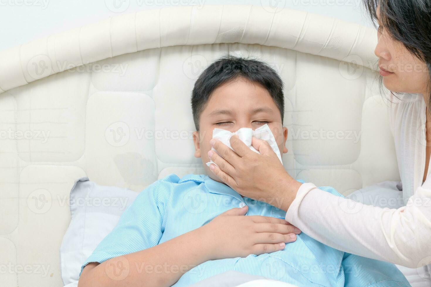 enfermo asiático niño limpiando o limpieza nariz con pañuelo de papel foto