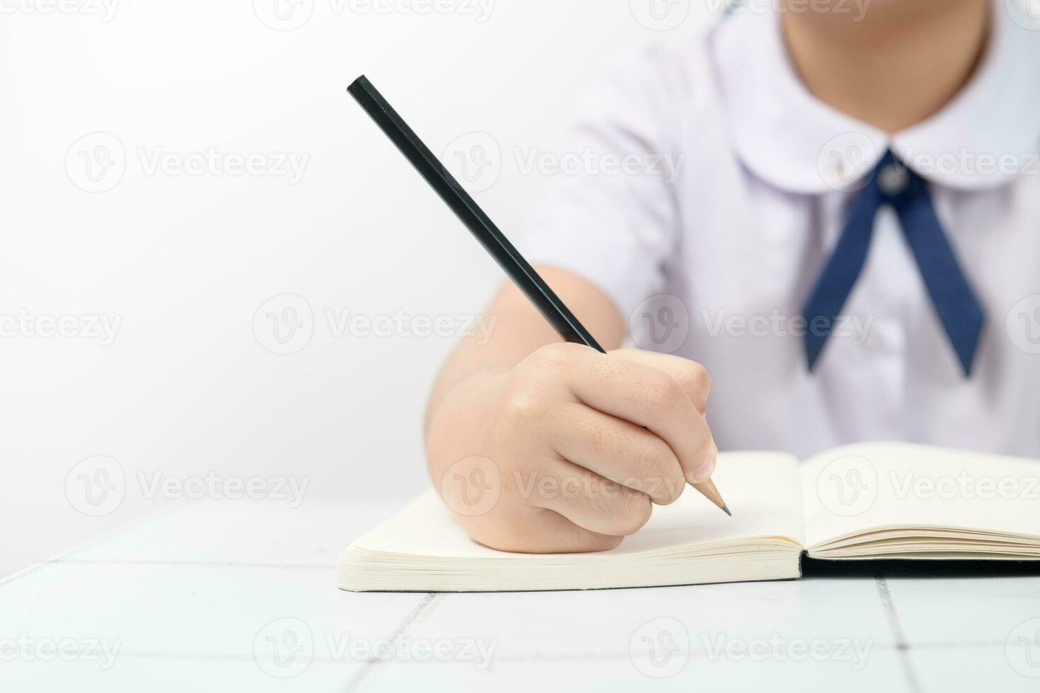 Close-up of writing hands of uniform students photo
