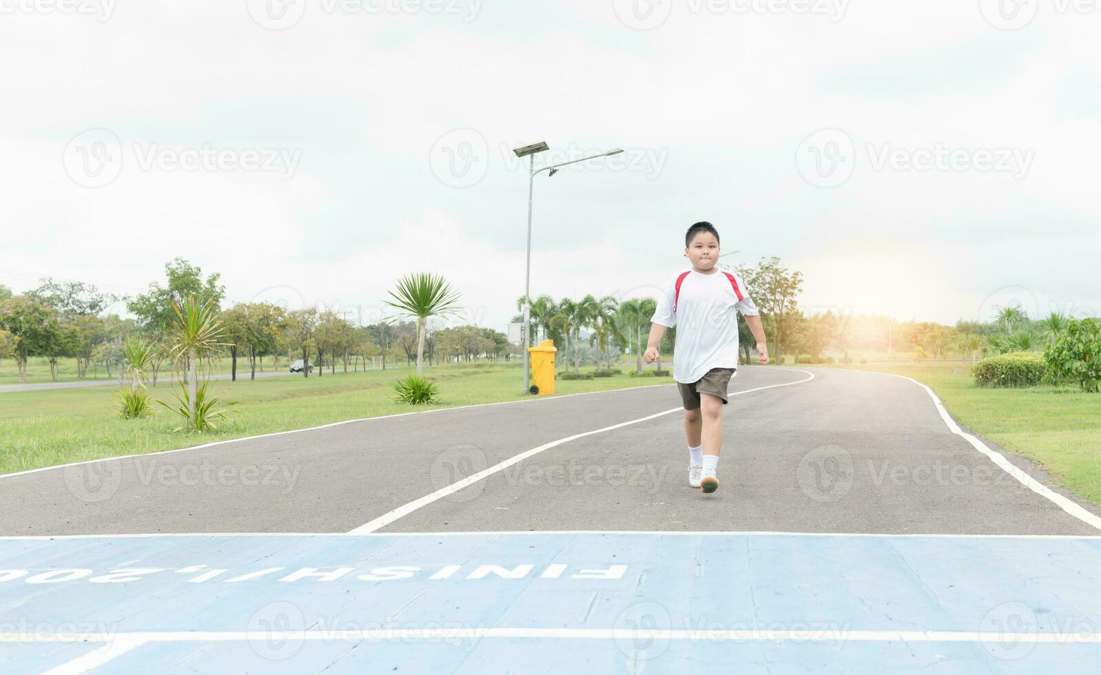 Obese fat boy walking to the finished line. photo