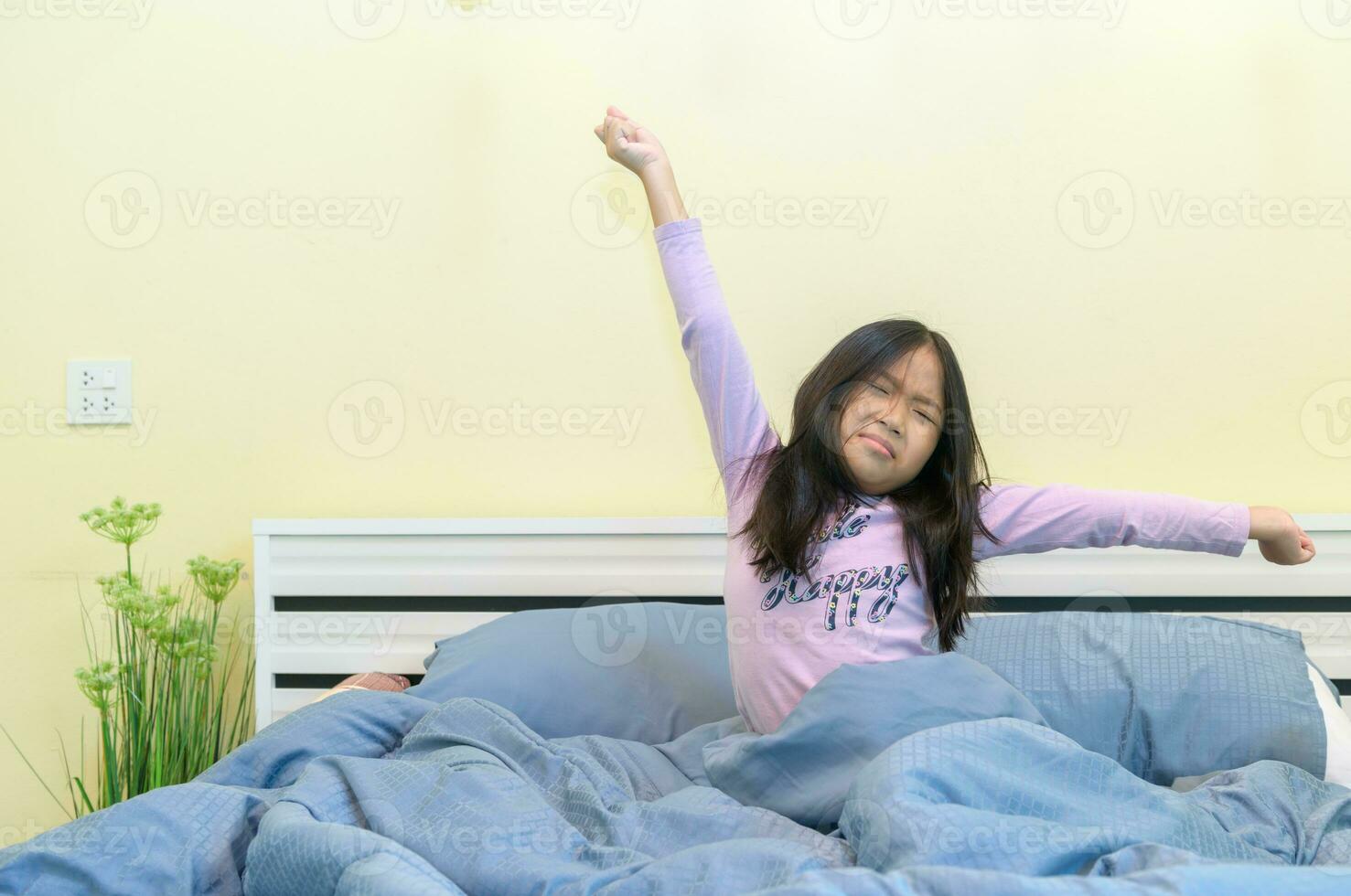 Cute girl stretching in bed after waking up, photo