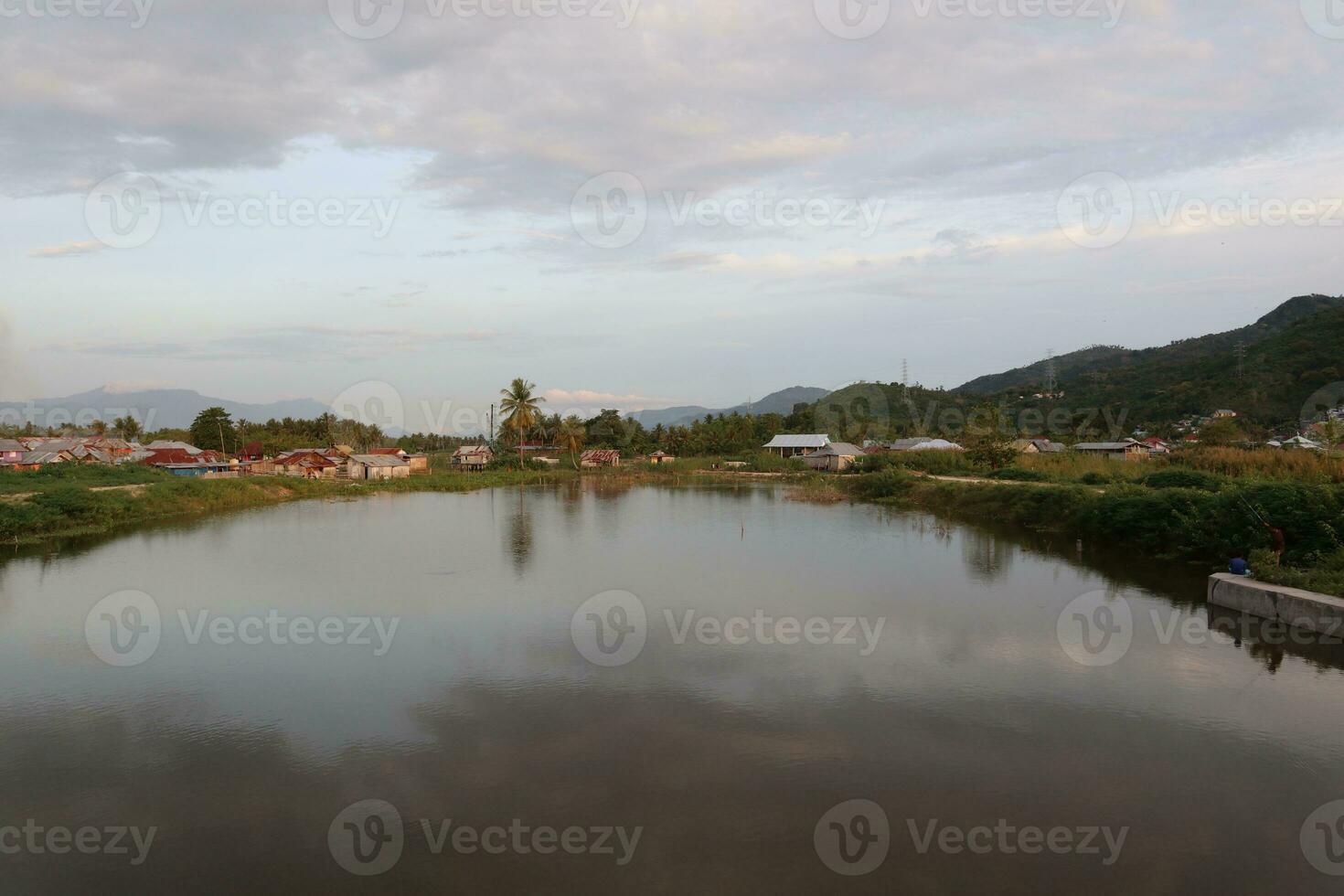 A village by the water with mountains in the background photo