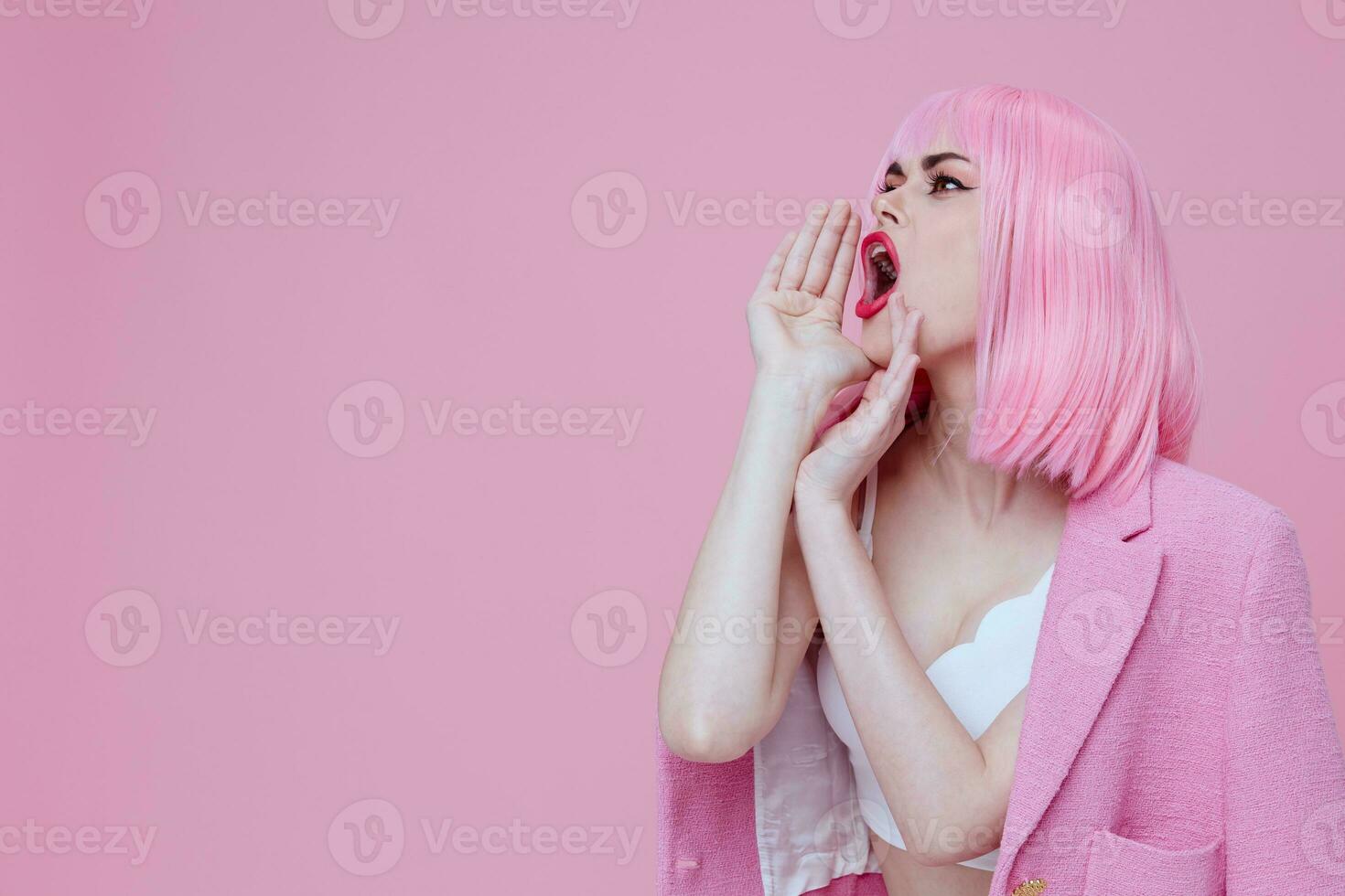 hermosa de moda niña en un rosado traje gesticulando con su manos emociones divertido monocromo Disparo inalterado foto