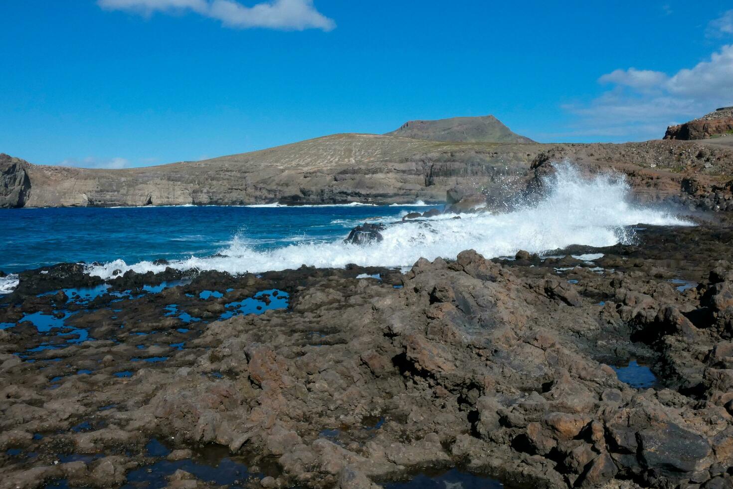 Large waves crashing against the rocks in the ocean photo