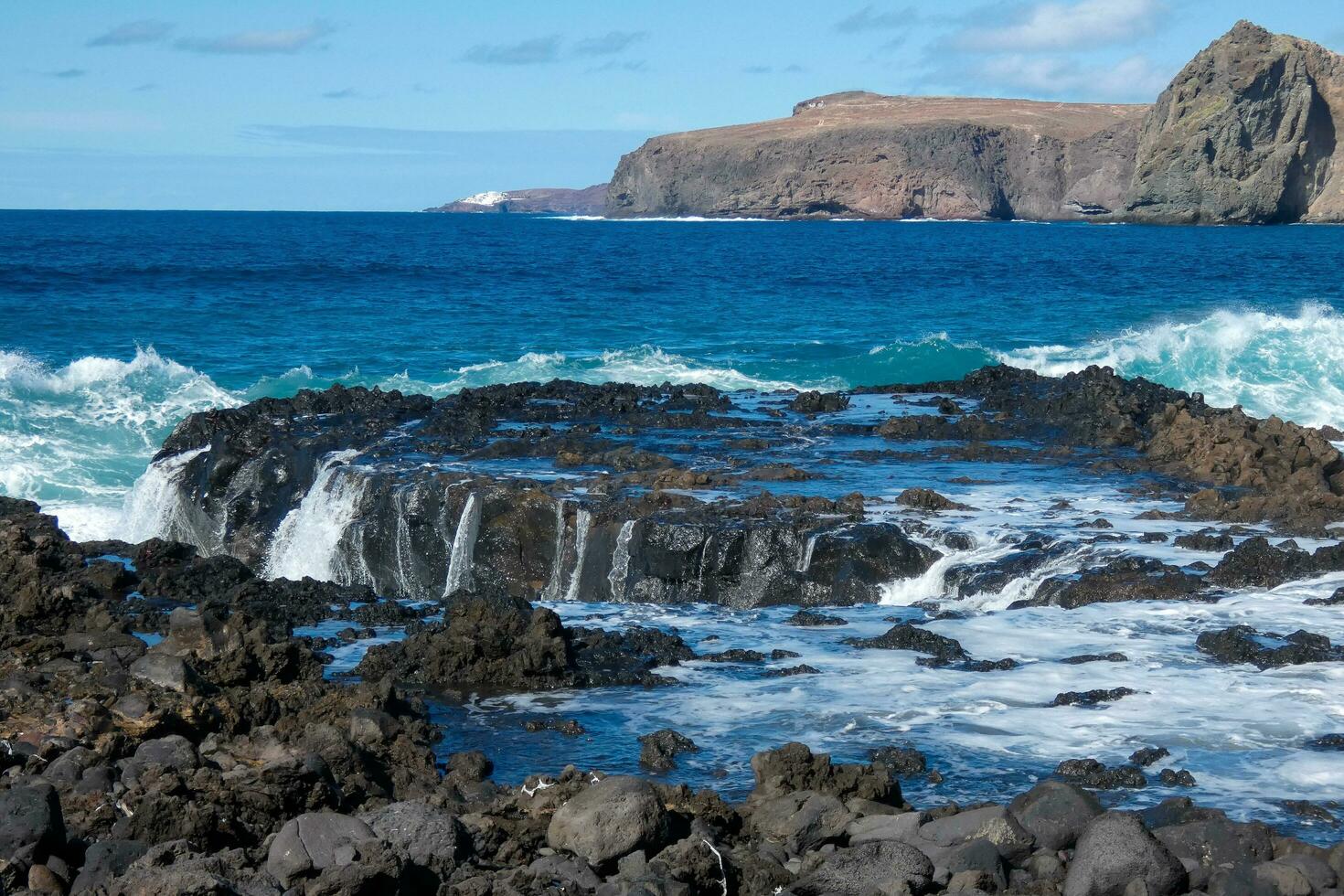 grande olas estrellarse en contra el rocas en el Oceano foto