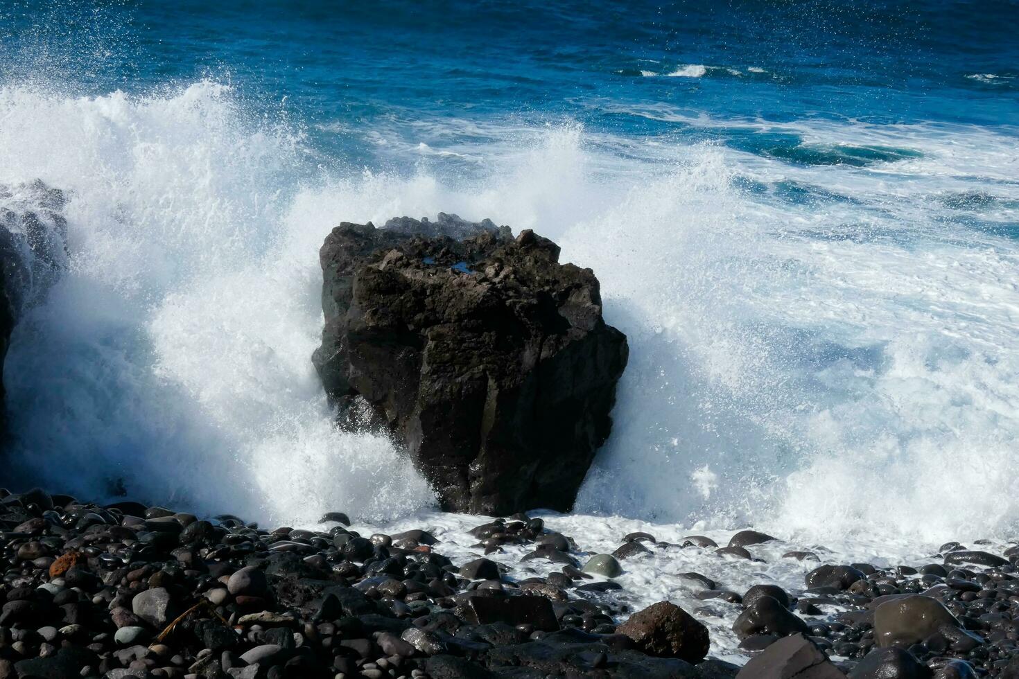 Large waves crashing against the rocks in the ocean photo